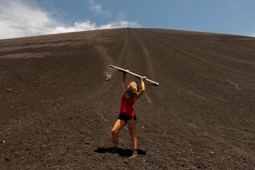 Annika met een board hoog in de lucht onderaan vulkaan Cerro Negro