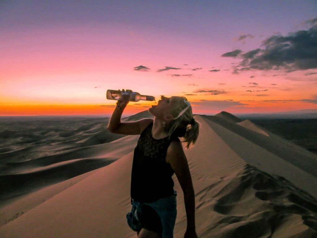 Annika drinking vodka on top of the sand dunes Khongoryn Els