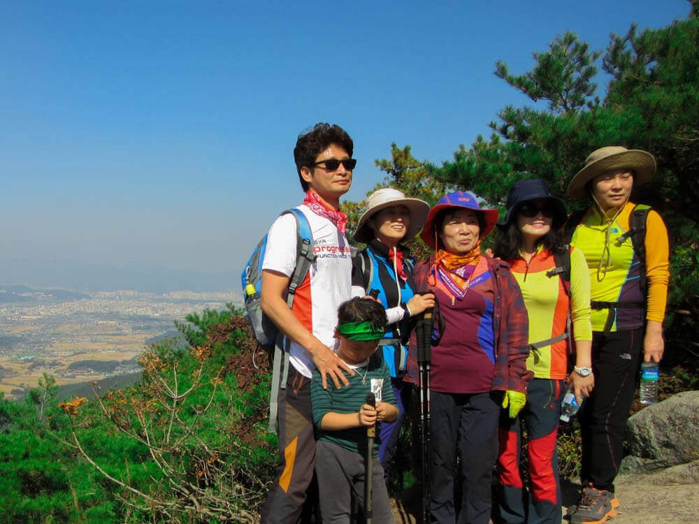 Korean family poses for a picture on top of a mountain