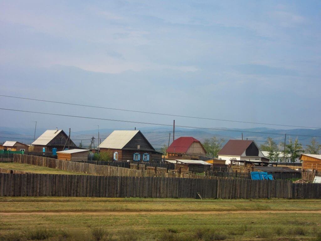 Huizen langs het spoor van de Transsiberië Express in Rusland
