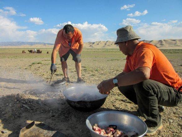 Mongolian tour guide preparing Mongolian barbecue underground near Khongoryn Els.